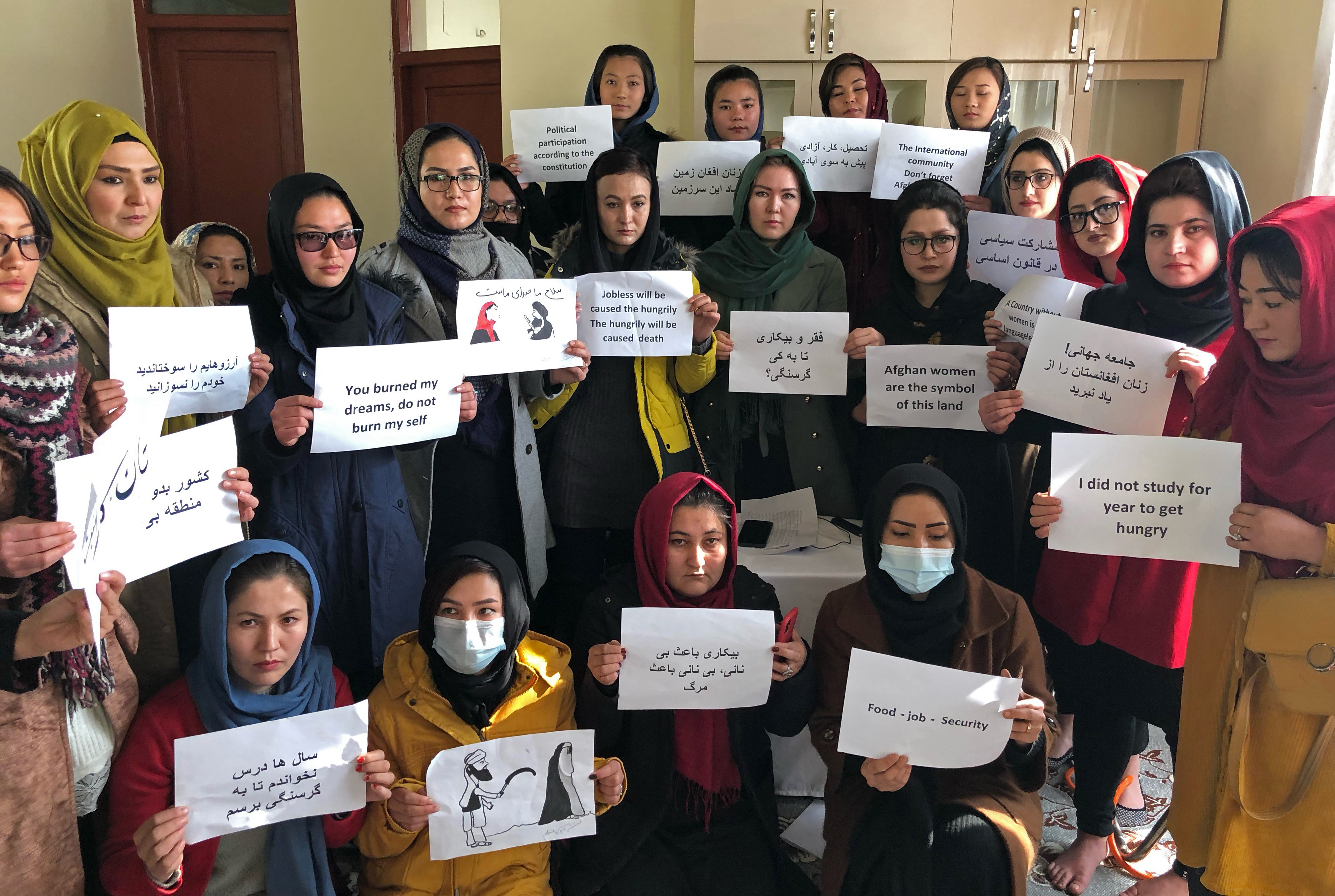 Afghan women chant and hold signs of protest, in Kabul, Afghanistan, Monday, Dec. 27, 2021.